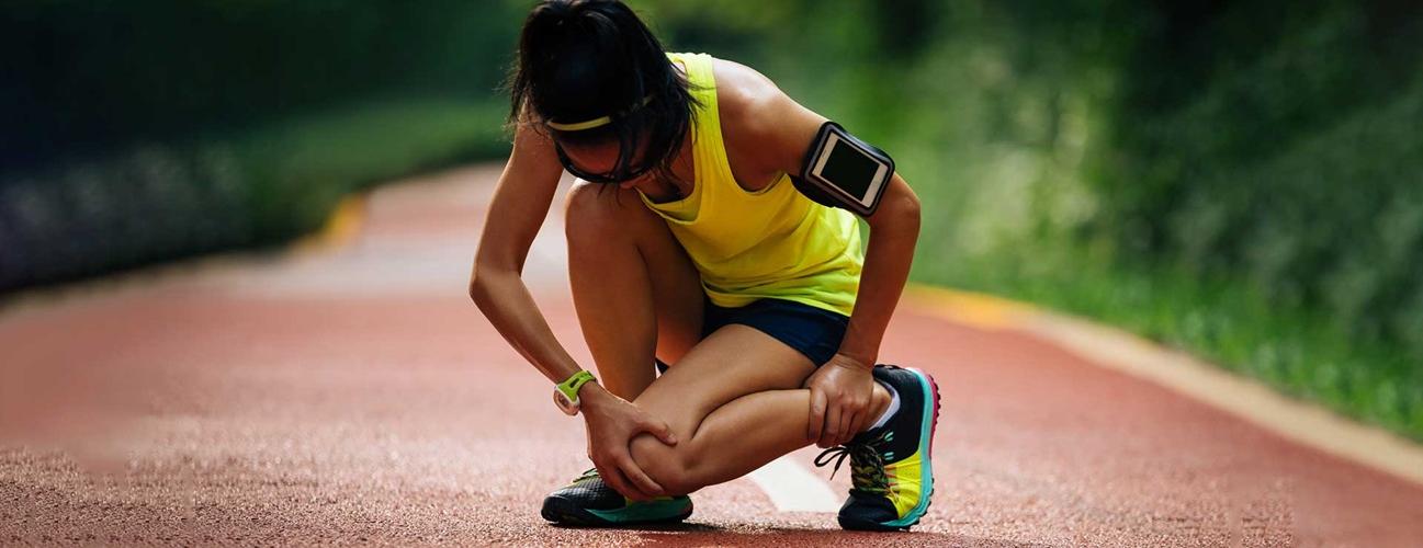 woman runner holding her knee in pain